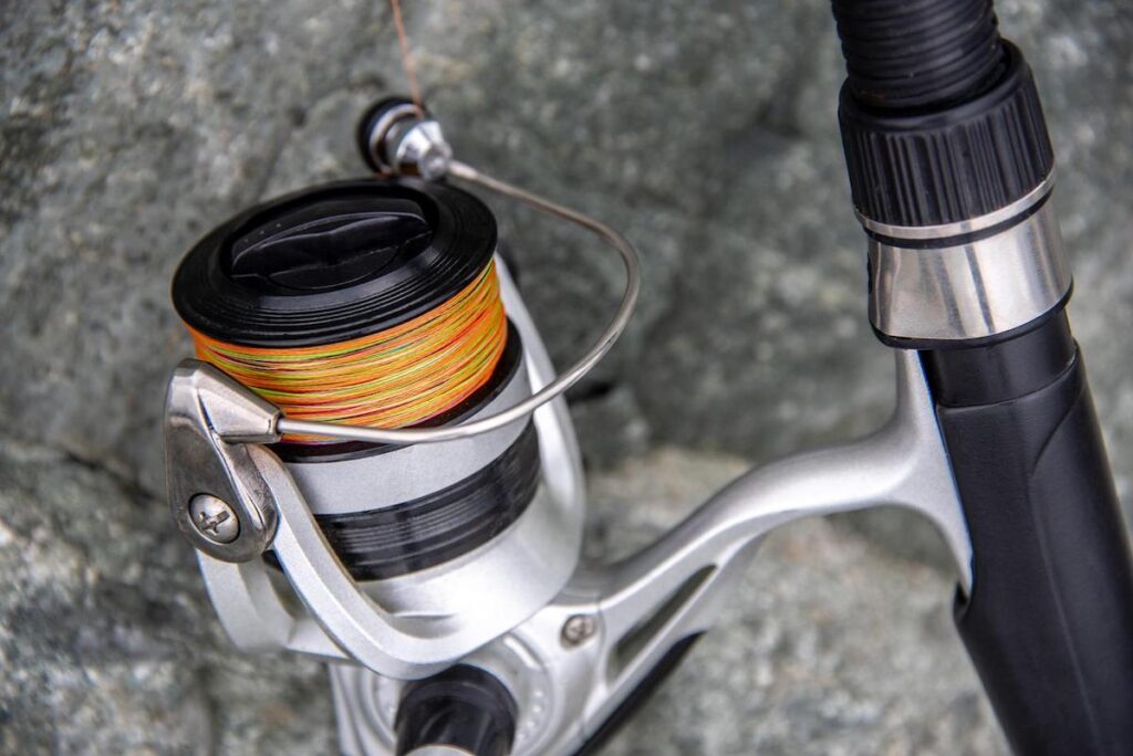 close up of spinning reel attached to rod